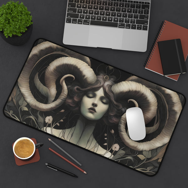 a computer mouse and a mouse pad with an artistic design depicting a woman's face surrounded by large, curled horns.