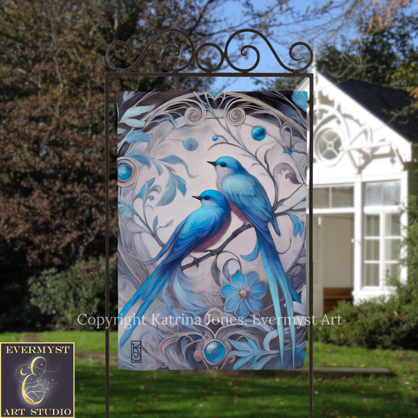 a beautiful painting of two blue birds perched on a branch, surrounded by intricate floral designs. The painting is displayed on a metal frame, which is placed in front of a white house.