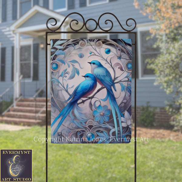 a large, ornate metal sign with a painting of two blue birds perched on a branch, surrounded by intricate floral designs.