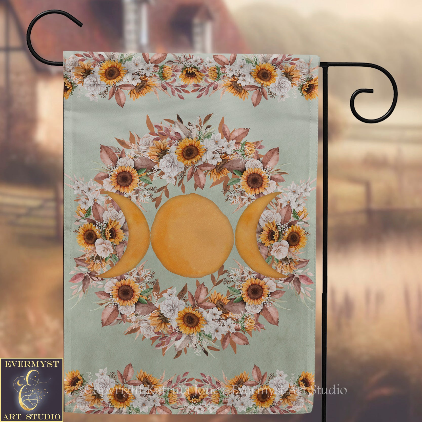a banner with a floral design and three crescent moons, hanging on a metal hook.