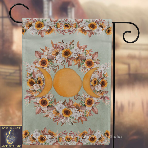 a banner with a floral design and three crescent moons, hanging on a metal hook.
