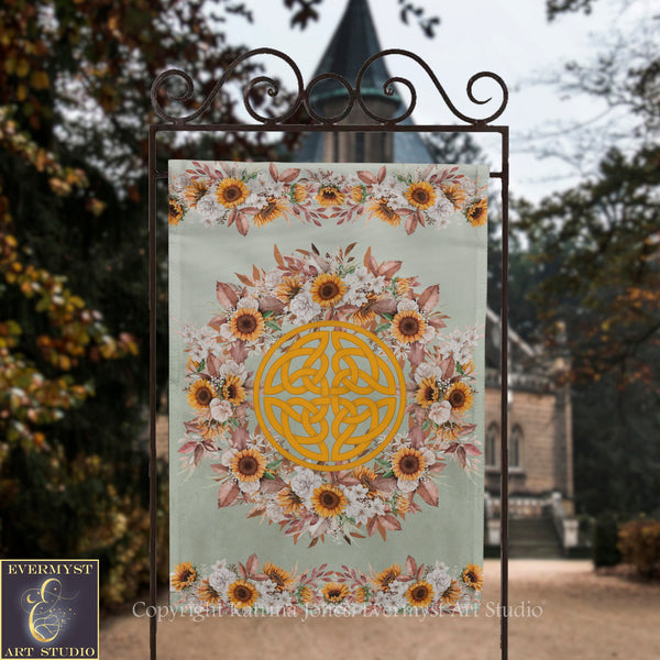 A banner with a floral design and a Celtic knot in the center, displayed outdoors in front of a building.