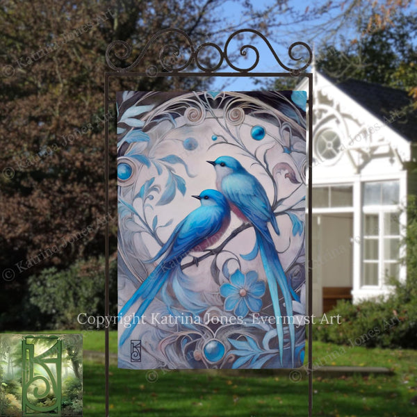 a beautiful painting of two blue birds perched on a branch, surrounded by intricate floral designs. The painting is displayed on a metal frame, which is placed in front of a white house.