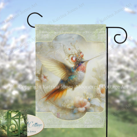 A colorful hummingbird with a decorative headdress is depicted on a flag, set against a blurred background of flowers.