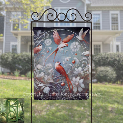 a vibrant painting of birds in a garden, with a large bird in the center surrounded by smaller birds and flowers. The painting is displayed on a metal stand in front of a house, creating a picturesque scene.