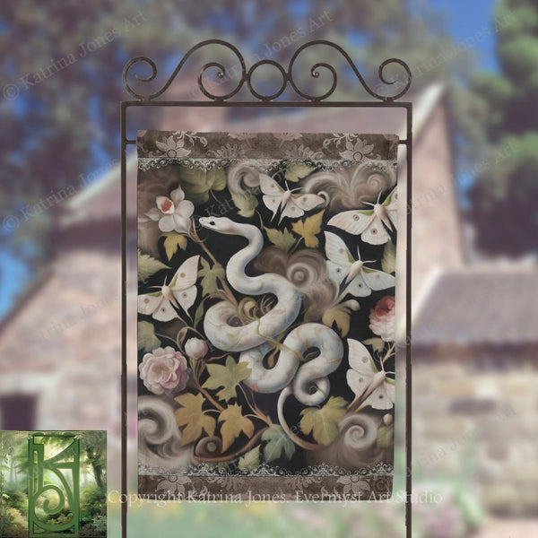 a decorative banner with a snake and butterflies on a metal frame, set against a blurred background of trees and a building.