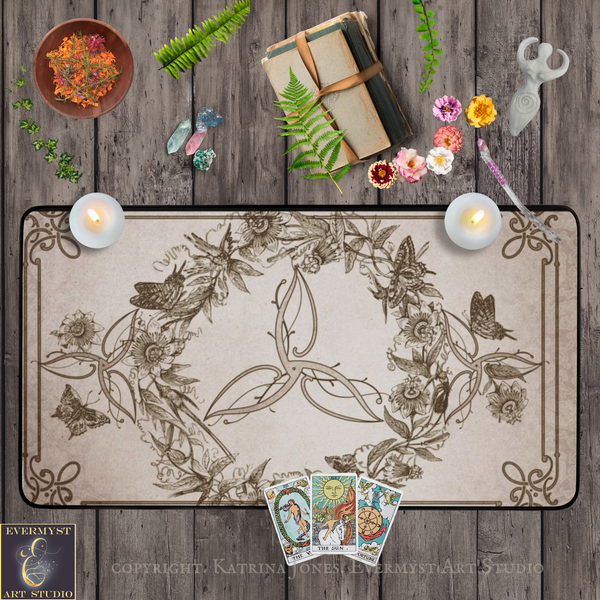a variety of objects arranged on a wooden surface, including candles, flowers, a book, scissors, and tarot cards.