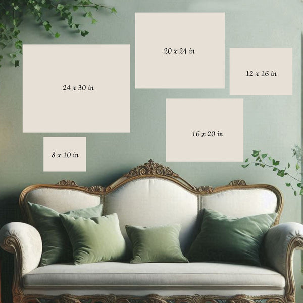 a white sofa with green throw pillows, and there are five framed artworks of varying sizes displayed on the wall above the sofa.