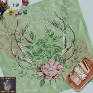 a table with a deer antlers and flowers on it