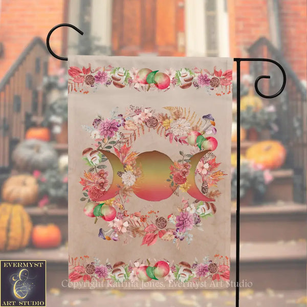 A decorative flag with a floral design and a crescent moon motif, hanging on a metal hook.