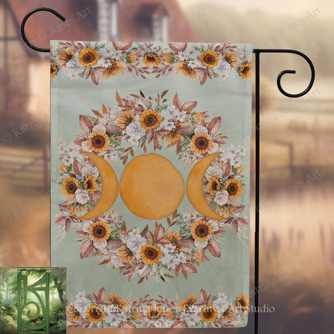 a banner with a floral design and three crescent moons, hanging on a metal hook.