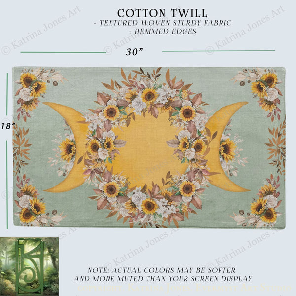 The image is a printed fabric with a floral design featuring sunflowers and crescent moons. The fabric has a textured woven appearance and is described as a cotton twill with hemed edges.